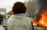 "Macron démission" peut-on lire sur ce gilet jaune, sur les Champs Elysées, le 24 novembre 2018