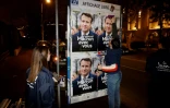 Des sympathisants de LREM collent des affiches de campagne d'Emmanuel Macron, à Vanves, en région parisienne, le 16 mars 2022