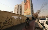 Un cycliste passe devant une peinture murale anti-américaine, le 6 janvier 2026 à Téhéran