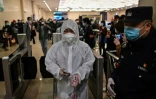 Un homme en combinaison protectrice entre dans la gare de  Hankou à Wuhan pour embarquer dans l'un des premiers trains à quitter la ville chinoise après deux mois et demi de bouclage à cause du coronavirus, le 8 avril 2020