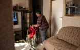 Lilly Stebe donne de l'eau à sa fille adoptive, Okuhle, née avec une paralysie cérébrale, dans leur maison de Snake Park, à Soweto, le 23 mai 2025 en Afrique du Sud