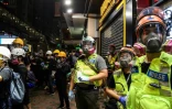 Des secouristes volontaires observent les manifestants pro-démocratie qui se rassemblent dans le quartier de Causeway, le 4 août 2019 à Hong Kong