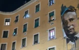Des habitants de Rome allument la torche de leur téléphone aux fenêtres le soir, de façon concertée, dans le quartier Garbatella à Rome, le 15 mars 2020