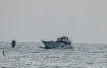 Un bateau de la flottille de Gaza (L), intercepté par la marine israélienne, est dirigé vers le port d'Ashdod, au sud de Tel Aviv, le 19 mai 2026