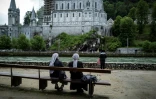 Des pèlerins devant la basilique Notre-Dame du Rosaire avant la réouverture du sanctuaire de Lourdes, fermé pour la première fois de son histoire pendant deux mois, pour cause d'épidémie, le 16 mai 2020 à Lourdes