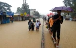 Des habitants dans une rue inondée, le 18 juin 2022 à Silhet, au Bangladesh