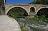 Des personnes naviguent en canot pneumatique sur le Tibre, passant devant l'île Tibérine, sur un tronçon du fleuve situé entièrement dans la zone urbaine du centre de Rome, le 14 août 2026