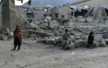 Des enfants devant des maisons détruites par un séisme, le 25 juin 2022 dans la province de Paktika, en Afghanistan