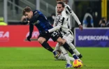 Le milieu de terrain français de la Juventus Adrien Rabiot tacle son homologue de l'Inter Milan Nicolo Barella, lors de la Supercoupe d'Italie, le 12 janvier 2022 au Stade San Siro