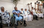 Solomon Daniel Yohanes (2e g) écoutent les élèves de l'école Eman Begena jouer de la béguna à la maison de retraite Grace Nursing Home à Addis Abeba, le 13 février 2025 en Ethiopie 