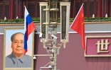 Le drapeau national russe (g) flotte à côté du drapeau chinois près d'un portrait du défunt dirigeant communiste Mao Tsé-toung devant la porte de Tiananmen, lors de la visite d'Etat du président russe Vladimir Poutine à Pékin, le 16 mai 2024