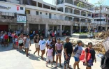 Des habitants font la queue pour une distribution de repas, le 5 novembre 2023 à Acapulco, deux semaines après le passage de l'ouragan Otis au Mexique