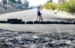 Un cycliste est photographié sur une route que des manifestants ont barré avec des pneus, à Byblos, au nord de Beyrouth, Liban, le 22 octobre 2019