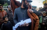 Un Palestinien, Yahya al-Batran, tient dans ses bras son nouveau-né Joumaa, qui serait décédé d'hypothermie, enveloppé dans un drap blanc, à l'hôpital des Martyrs d'Aqsa à Deir el-Balah, dans le centre de la bande de Gaza, le 29 décembre 2024