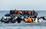 Des migrants montent à bord d'un bateau de passeurs pour tenter de traverser la Manche, au large de la plage de Gravelines, dans le nord de la France, le 26 mars 2025
