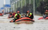 Des secouristes évacuant des habitants de la ville inondée de Zhenzhou en Chine, le 22 juillet 2021