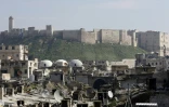 Une photo prise le 12 février 2019 montre une vue générale du marché de  Saqatiya à Alep en partie détruit par la guerre en Syrie, ainsi que la citadelle d'Alep 