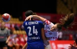 L'arrière droite croate Dejana Milosavljevic tire au but malgré la défense du pivot français Béatrice Edwige, lors de leur demi-finale de l'Euro-2020, le 18 décembre 2020 à Herning (Danemark)