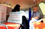 Une Yéménite, assise près de son fils malade dans une ambulance, tient une pancarte appelant à lever le blocus à l'aéroport de Sanaa, en attendant l'arrivée de l'émissaire de l'ONU Martin Griffiths, le 5 janvier 2019