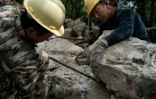 Des ouvriers travaillent à la réfection de la Grande muraille de Chine le 17 mai 2019 à Xiangshuihu