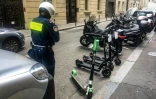 Un agent range des trottinettes dans un emplacement dédié à Paris en juin 2019