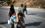 Un candidat à l'émigration montre son passeport yéménite alors qu'il est raccompagné par des militaires jusqu'au poste-frontière entre le Maroc et l'enclave espagnole de Ceuta, le 2 août 2026 
