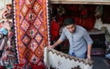 Un vendeur montre des tapis traditionnels dans une échoppe du marché de Hilla, le 12 octobre 2017 en Irak