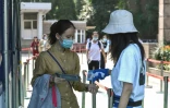 Contrôle de température avant d'entrer dans un établissement scolaire pour une élève qui va passer le bac à Nanjing, le 7 juillet 2020