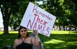 Une femme tient une pancarte  où est inscrit "souvenez-vous de leurs noms", à Uvalde (Texas), le 25 mai 2022