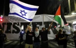 Des drapeaux israélien et palestinien brandis lors d'une manifestation d'Arabes israéliens contre une loi définissant Israël comme "l'Etat-nation du peuple juif", le 11 août 2018 à Tel-Aviv