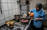 La chef cuisinière syrienne Malakeh Jazmati, devant les fourneaux de son restaurant, prépare des repas gratuits pour les salariés des supermarchés, le 21 avril 2020 à Berlin, en Allemagne