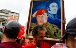 Des sympathisants du président vénézuélien Nicolas Maduro exhibent un portrait de l'ancien chef de l'Etat Hugo Chavez à Caracas le 22 juin 2016