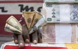 Un cambiste montre des francs congolais sur un marché de Kinshasa, le 11 août 2021 en RDC