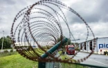 Une clôture de barbelés autour de parkings d'une zone logistique à Marck, le 28 août 2023 dans le Pas-de-Calais