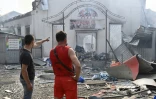 Des habitants devant un marché touché par un bombardement à Sloviansk, Ukraine, le 3 juillet 2022