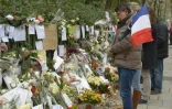 Un homme avec un drapeau tricolore  le  27 novembre 2015 devant le Bataclan à Paris