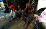 Le Vénézuélien José Carrizales (d) dans un campement de fortune près d'une gare de bus, le 9 août 2018 à Quito, en Equateur