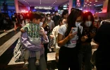 Des clients fuient le centre commercial Siam Paragon à Bangkok, théâtre d'une fusillade meurtrière le 3 octobre 2023
