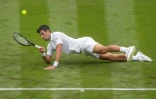 Le Serbe Novak Djokovic glisse lors de son match du 1er tour contre le Britannique Jack Draper, le 28 juin 2021 au tournoi de Wimbledon à Londres