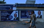 Des gens passent devant une affiche de campagne de Succès Masra, candidat à la présidentielle tchadienne, le 4 mai 2024 à N'Djamena