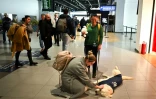 Une voyageuse caresse Dino, un golden retriever conduit par sa dresseuse Vesna Kiskovska (d) à l'aéroport international de Skopje, le 29 janvier 2025 en Macédoine du Nord
