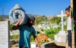 Un Vénézuélien porte un matelas dans le cimetière de Caracas où il réside, le 10 février 2021