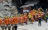 Des secouristes se rassemblent face au tunnel effondré de Silkyara où sont bloqués 41 ouvriers, en Inde le 28 novembre 2023