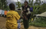 Marie-Thérèse Tsesi, une nourrice de 63 ans, plie du linge avec l'un des cinq enfants orphelins d'Ebola dont elle s'occupe à son domicile à Mongbwalu, dans le nord-est de la RDC, le 11 octobre 2026
