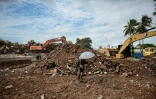 Un engin de chantier dégage le site où se trouvait un condominium, détruit lors du tremblement de terre du 28 mars, le 16 septembre 2025 à Mandalay, en Birmanie