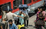 Des habitants tentent de monter dans un train à la gare de Jammu, le 10 mai 2025 au Cachemire indien