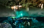 Des touristes nagent dans un cénote près du site de construction du Train Mayan, entre Tulum et Playa del Carmen, le 27 avril 2022 au Mexique