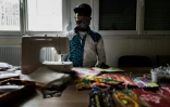 Un homme coud des masques dans une école temporairement reconvertie en centre d'accueil pour migrants, le 16 avril 2020 à Lyon