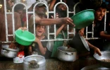 Des Palestiniens attendent un repas chaud distribué par une cantine caritative à Khan Younès, dans le sud de la bande de Gaza, le 22 juillet 2025