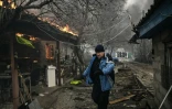Un homme marche au millieu des maisons en feu à Irpin, en Ukraine, le 4 mars 2022